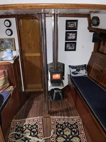 Slide: The Image of Interior of a 1976 Westsail Ketch with cozy wood stove and nautical decor. - 3