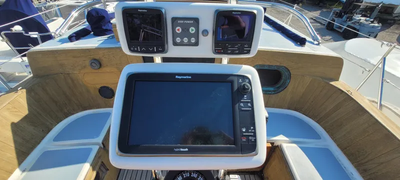Slide: The Image of 1976 Westsail Ketch cockpit with navigation equipment and wooden paneling. - 33