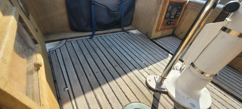 Slide: The Image of 1976 Westsail Ketch cockpit with wooden flooring and nautical equipment. - 35