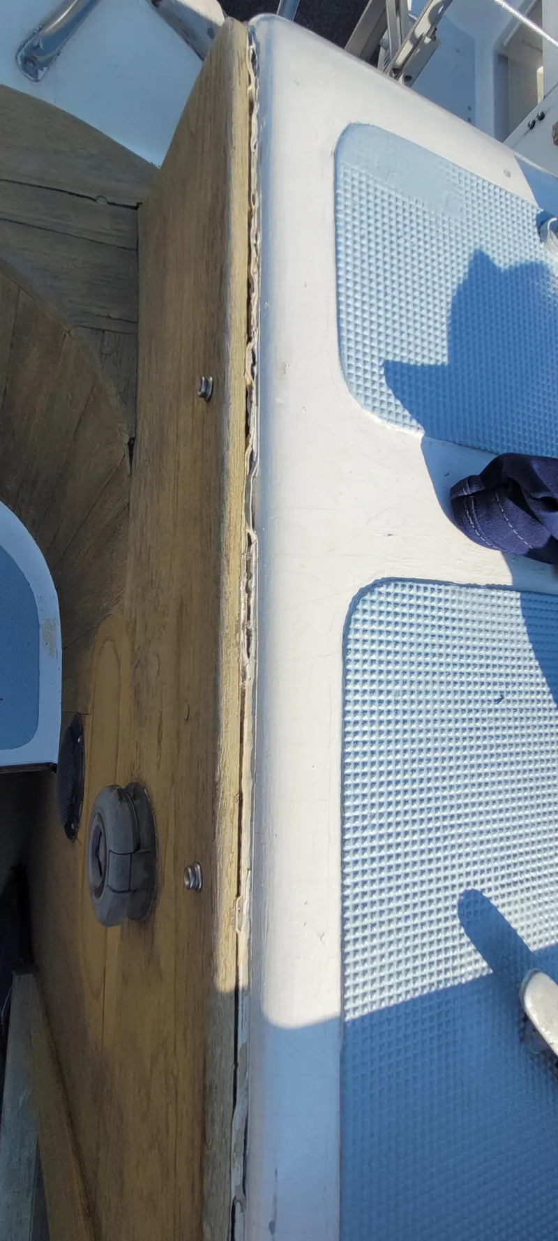 Slide: The Image of 1976 Westsail Ketch deck with wooden and textured surfaces, partial view. - 37