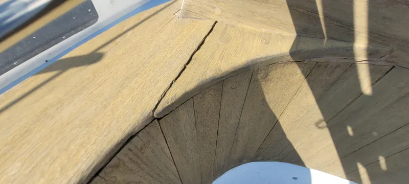 Slide: The Image of Wooden deck detail of a 1976 Westsail Ketch, showing natural wear and shadow patterns. - 39