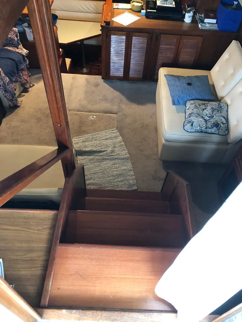 Slide: The Image of Interior of 1986 Chris-Craft Catalina boat with wooden stairs and cozy seating area. - 14