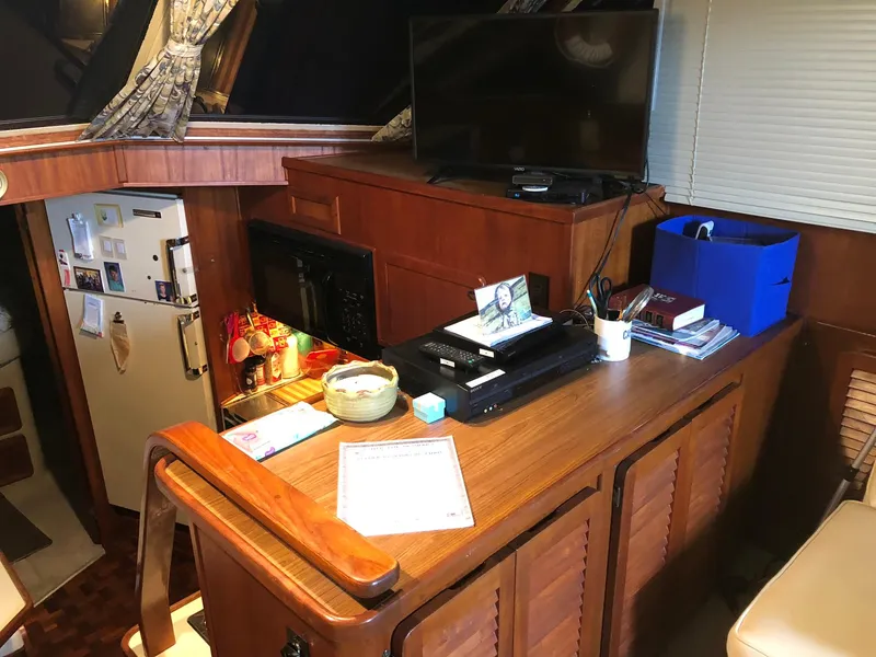 Slide: The Image of 1986 Chris-Craft Catalina interior with kitchenette, TV, and wooden cabinetry. - 18