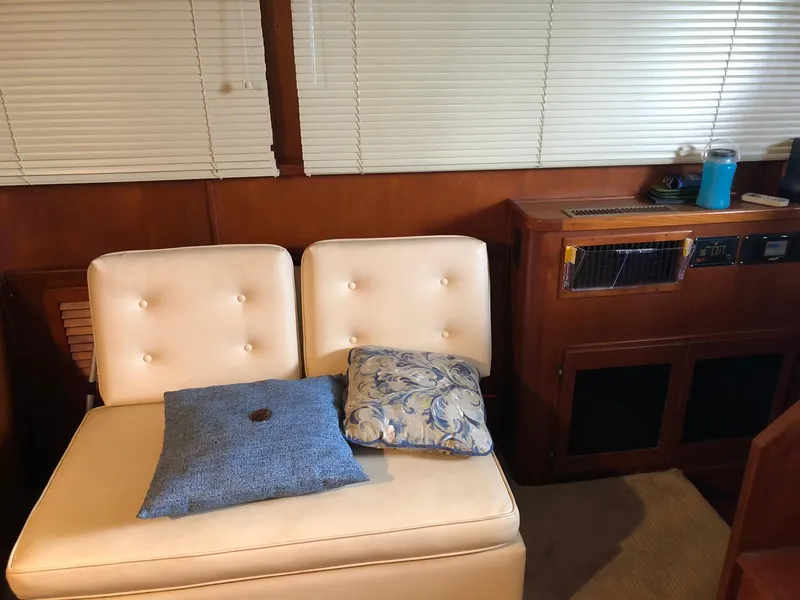 Slide: The Image of 1986 Chris-Craft Catalina interior with white cushioned seating and decorative pillows. - 19