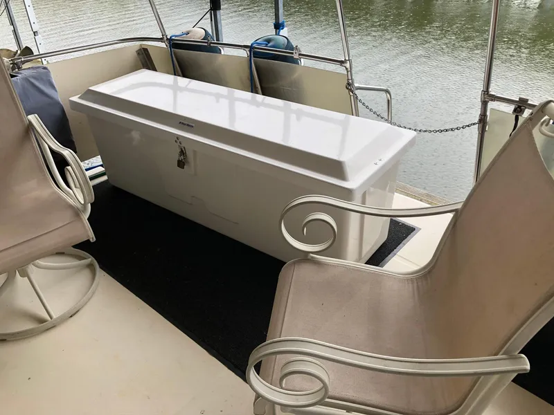 Slide: The Image of 1986 Chris-Craft Catalina boat interior with seating and storage box on deck. - 2