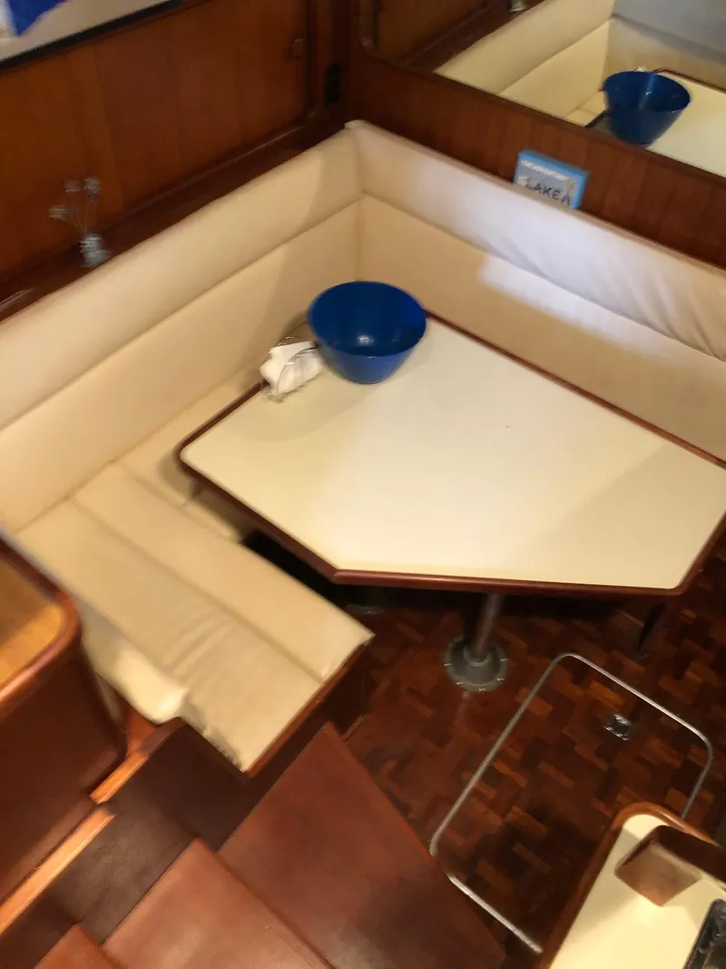 Slide: The Image of 1986 Chris-Craft Catalina interior dining area with cushioned seating and table. - 21