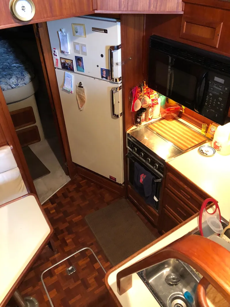 Slide: The Image of 1986 Chris-Craft Catalina kitchen area with appliances and wooden cabinetry. - 23