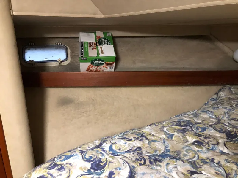 Slide: The Image of 1986 Chris-Craft Catalina cabin interior with a small window and bedding. - 29