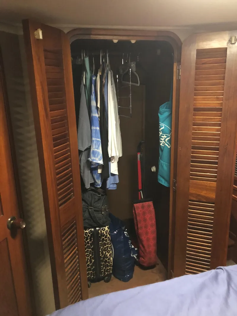 Slide: The Image of Closet interior on a 1986 Chris-Craft Catalina boat with clothes and bags. - 39