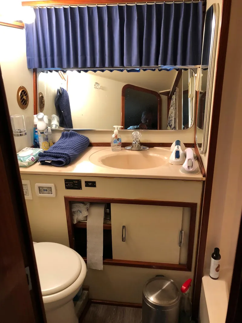 Slide: The Image of 1986 Chris-Craft Catalina bathroom with sink, mirror, toilet, and storage cabinets. - 41