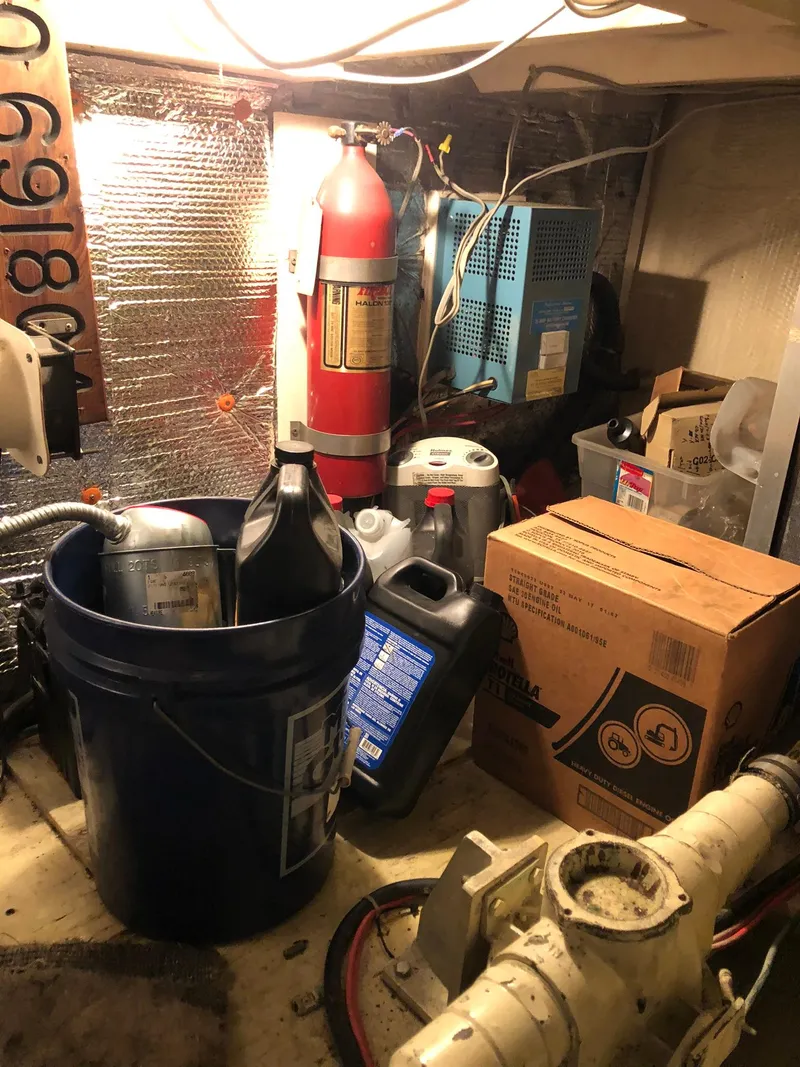 Slide: The Image of 1986 Chris-Craft Catalina engine room with fire extinguisher, oil containers, and maintenance supplies. - 46