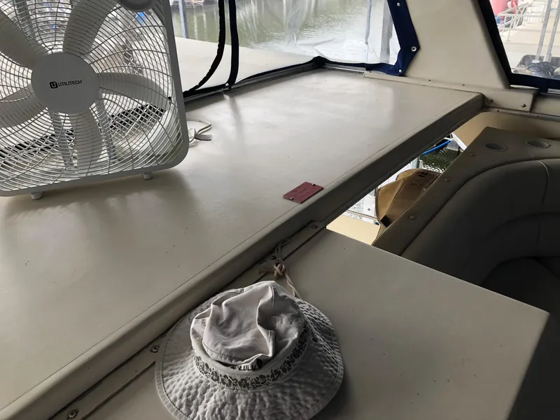 Slide: The Image of 1986 Chris-Craft Catalina interior with fan and hat on table. - 6