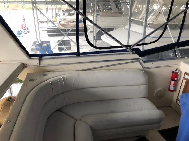 Slide: The Image of 1986 Chris-Craft Catalina boat interior with cushioned seating and docked yachts in background. - 7