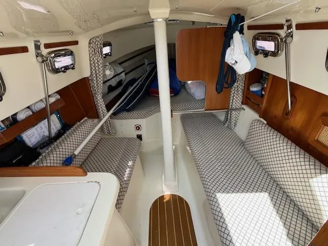 Slide: The Image of Interior of a 2010 Seaward 26RK sailboat with cushioned seating and storage. - 15