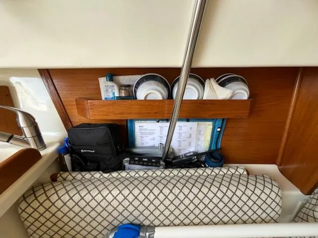 Slide: The Image of Interior storage area of a 2010 Seaward 26RK sailboat with various items neatly organized. - 23