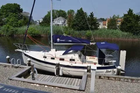 Slide: The Image of 2010 Seaward 26RK sailboat docked by a serene riverside. - 31