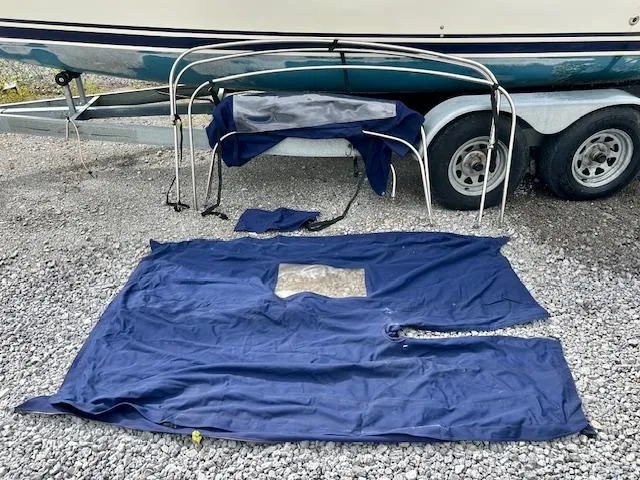 Slide: The Image of Blue canvas and frame for Seaward 26RK sailboat, displayed on gravel near trailer. - 32
