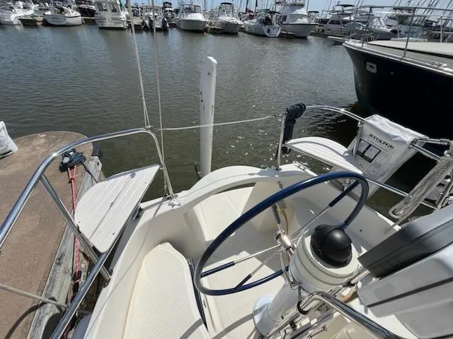 Slide: The Image of 2010 Seaward 26RK sailboat docked at a marina, view of the cockpit and steering wheel. - 7