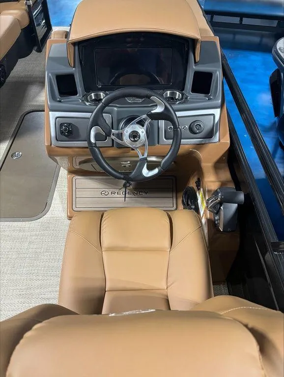 Slide: The Image of 2024 Regency 230 LE3 Sport boat dashboard with steering wheel and control panel. - 11