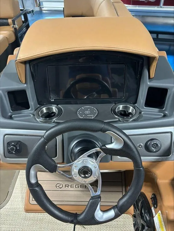 Slide: The Image of 2024 Regency 230 LE3 Sport boat dashboard with steering wheel and control panel. - 12