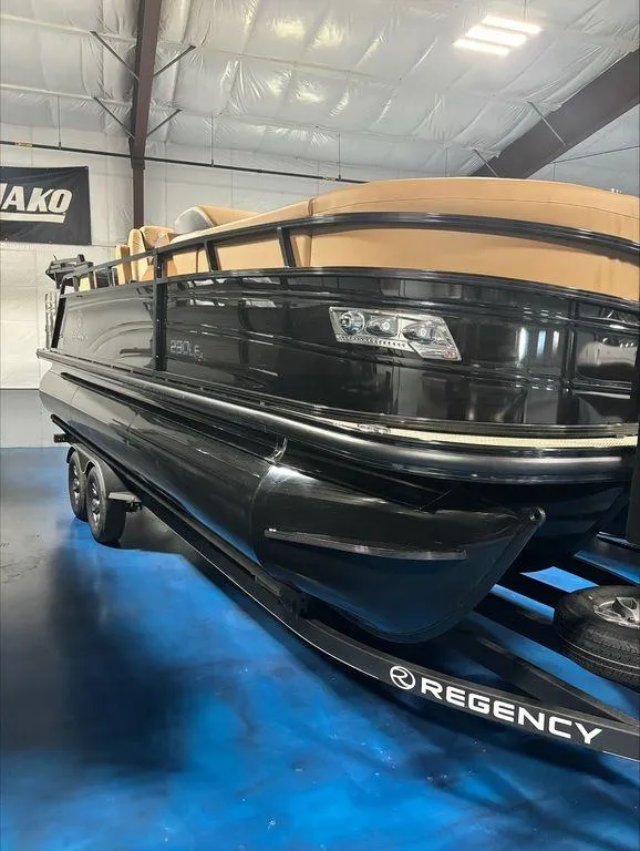 Slide: The Image of 2024 Regency 230 LE3 Sport pontoon boat in showroom. - 2