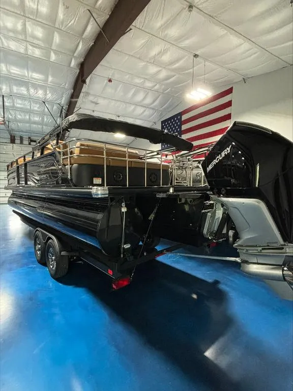 Slide: The Image of 2024 Regency 230 LE3 Sport boat in a showroom with an American flag. - 3