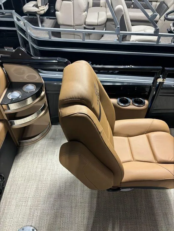Slide: The Image of 2024 Regency 230 LE3 Sport boat interior with tan leather seating and cup holders. - 5