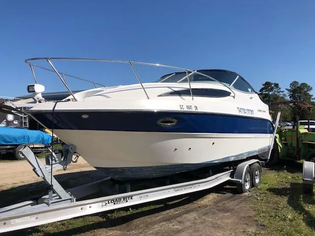 The Image of 2007 Bayliner 275 boat on Load Rite trailer, white and blue, parked outdoors. - 0
