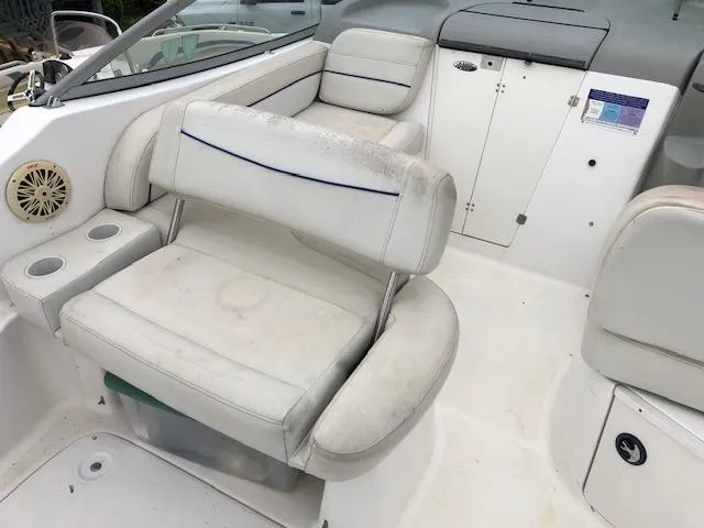 Slide: The Image of 2007 Bayliner 275 boat interior with white leather seating and storage compartments. - 11