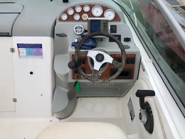 Slide: The Image of 2007 Bayliner 275 boat helm with steering wheel, gauges, and controls. - 14