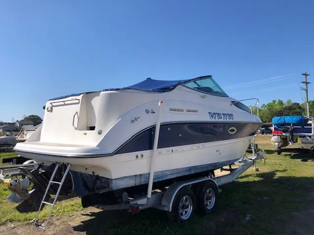 Slide: The Image of 2007 Bayliner 275 boat on a trailer in a yard. - 2