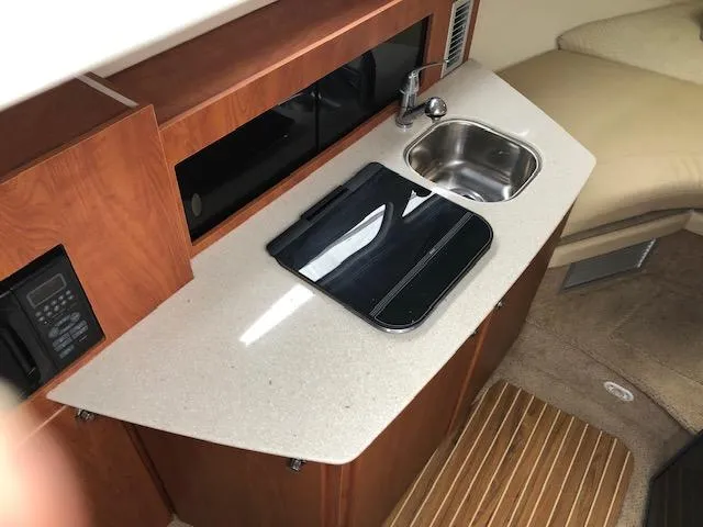 Slide: The Image of 2007 Bayliner 275 boat interior with kitchenette, sink, and countertop. - 20