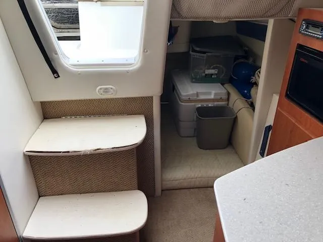 Slide: The Image of 2007 Bayliner 275 interior with steps, storage, and compact kitchen area. - 22