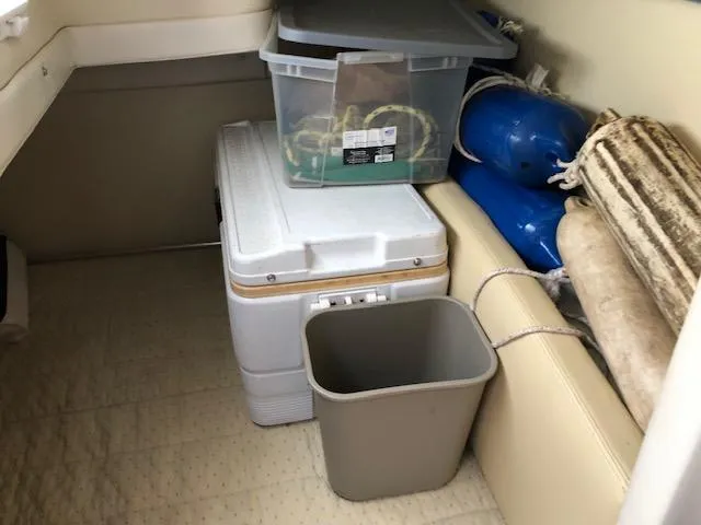 Slide: The Image of Interior storage area of a 2007 Bayliner 275 boat with cooler, bin, and fenders. - 24
