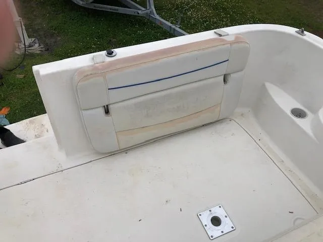 Slide: The Image of 2007 Bayliner 275 boat interior with worn white seating and deck. - 9