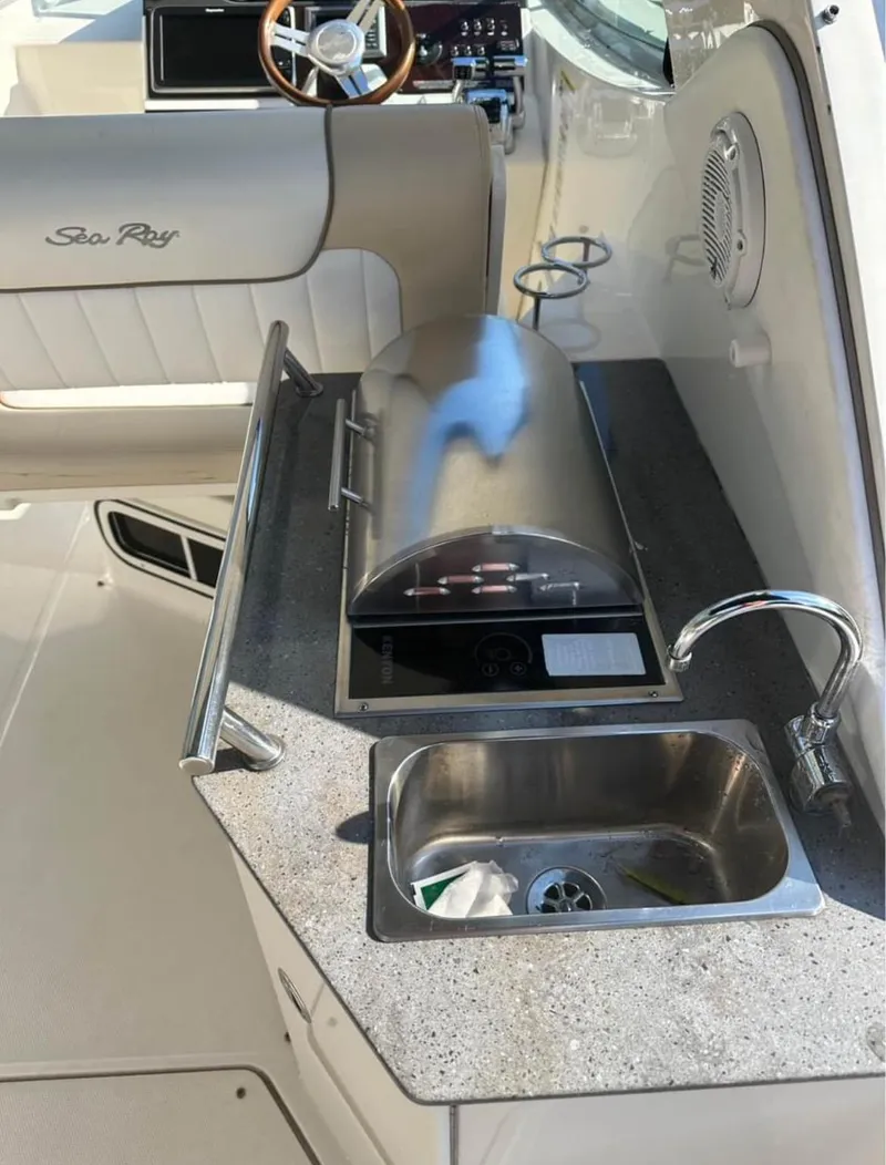 Slide: The Image of 2013 Sea Ray Sundancer boat interior with kitchenette, sink, and grill. - 11