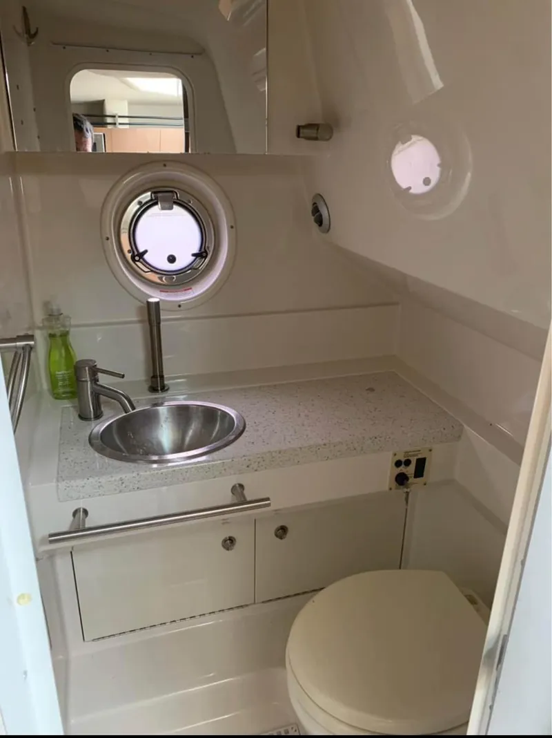 Slide: The Image of 2013 Sea Ray Sundancer bathroom with sink, porthole, and toilet. - 13