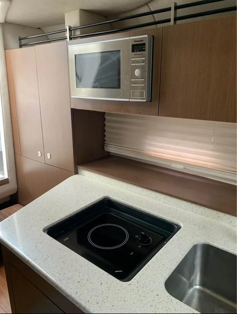 Slide: The Image of Modern kitchen area in a 2013 Sea Ray Sundancer yacht with microwave and stovetop. - 14