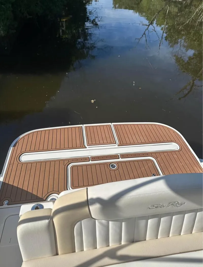 Slide: The Image of 2013 Sea Ray Sundancer boat deck on calm water, featuring teak flooring. - 15