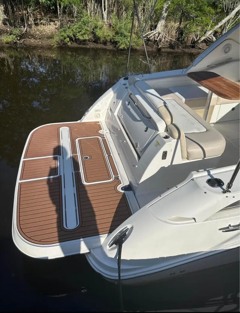 Slide: The Image of 2013 Sea Ray Sundancer boat with teak swim platform and seating area. - 16