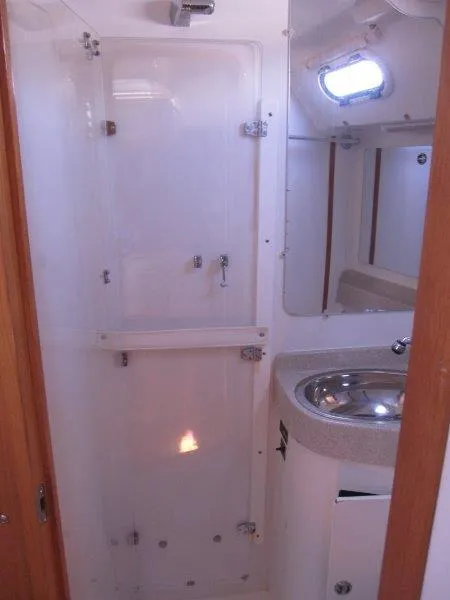Slide: The Image of 2007 Catalina MkII bathroom with shower, sink, and porthole window. - 12