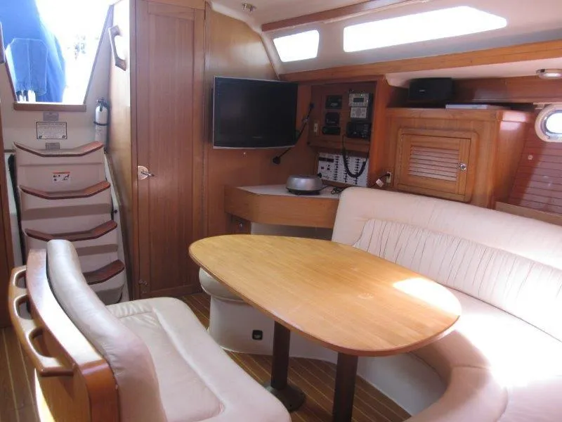 Slide: The Image of Interior of a 2007 Catalina MkII sailboat with a cozy dining area and navigation equipment. - 13