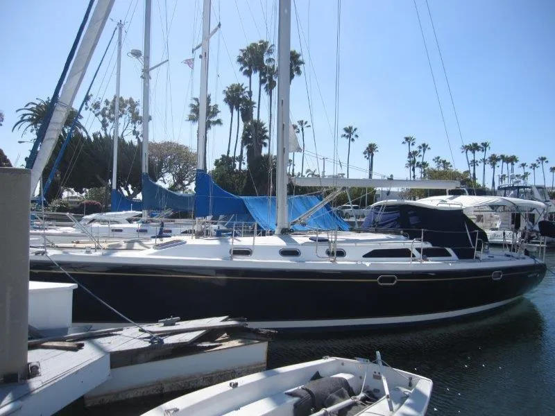 Slide: The Image of 2007 Catalina MkII sailboat docked in a marina with palm trees in the background. - 45
