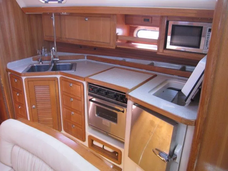 Slide: The Image of 2007 Catalina MkII yacht kitchen with wood cabinetry, stainless steel appliances, and double sink. - 5