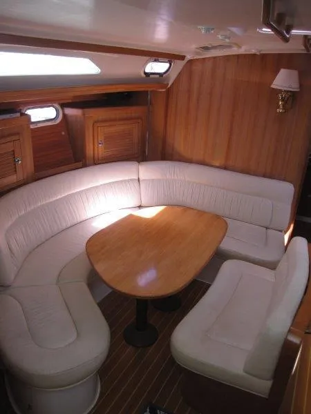 Slide: The Image of 2007 Catalina MkII sailboat interior with curved seating and wooden table. - 6