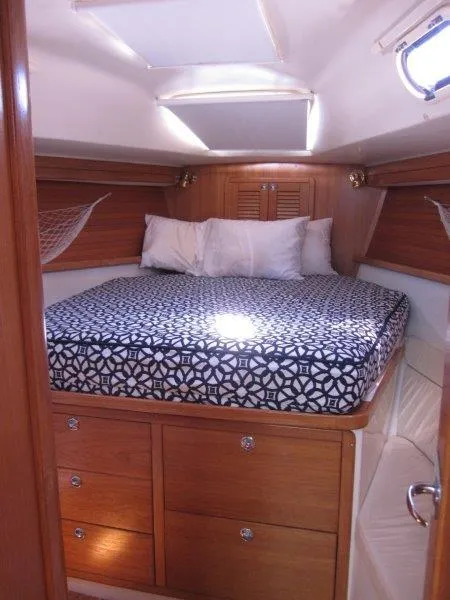 Slide: The Image of 2007 Catalina MkII cozy cabin with bed, wooden drawers, and porthole window. - 9
