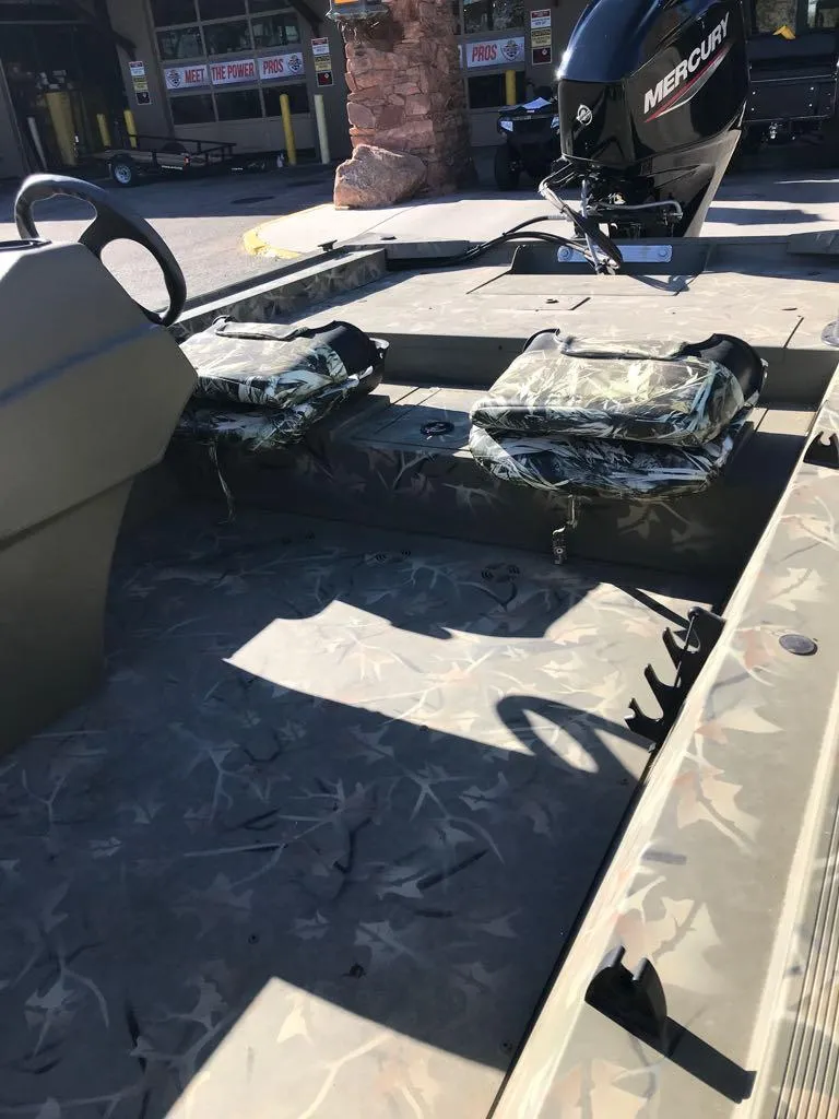 Slide: The Image of 2024 Tracker Grizzly 1754 SC boat interior with camo seats and Mercury engine. - 14