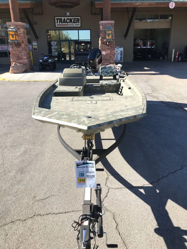 Slide: The Image of 2024 Tracker Grizzly 1754 SC boat displayed outside dealership. - 2