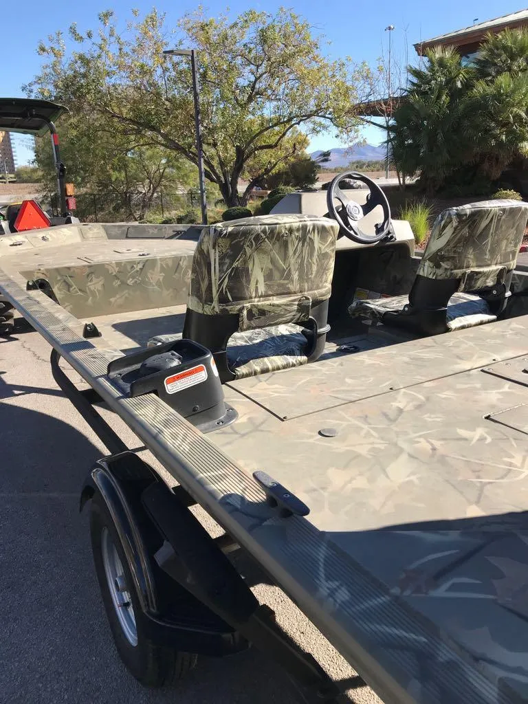 Slide: The Image of 2024 Tracker Grizzly 1754 SC boat with camouflage seats and steering wheel. - 6