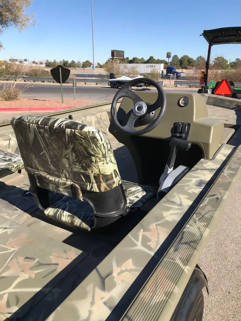 Slide: The Image of 2024 Tracker Grizzly 1754 SC boat with camouflage seating and steering console. - 8
